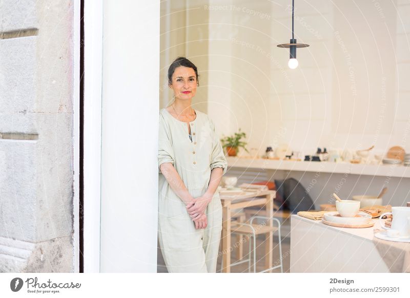 Woman in work wear in her workshop next to the window Crockery Leisure and hobbies Handcrafts Table Work and employment Profession Craftsperson Workplace Office