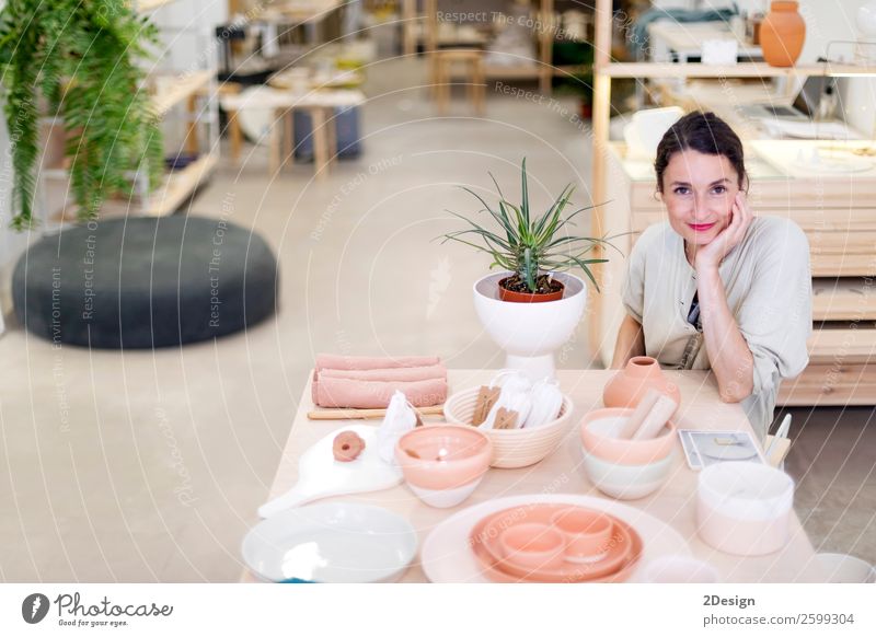 Woman in work wear in her workshop Crockery Leisure and hobbies Handcrafts Table Work and employment Profession Craftsperson Workplace Office Craft (trade)