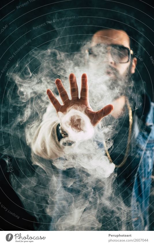 Smoking vape. vaping man holding a mod. Vape Rings. A man launches a ring of smoke. Tricks with smoke. Lifestyle Face Human being Man Adults Clouds Fashion