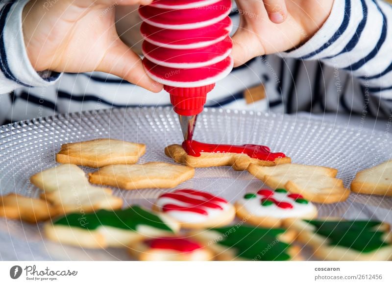 Little kid decorating Christmas biscuits at Christmas day Dough Baked goods Dessert Candy Joy Happy Decoration Table Kitchen Feasts & Celebrations