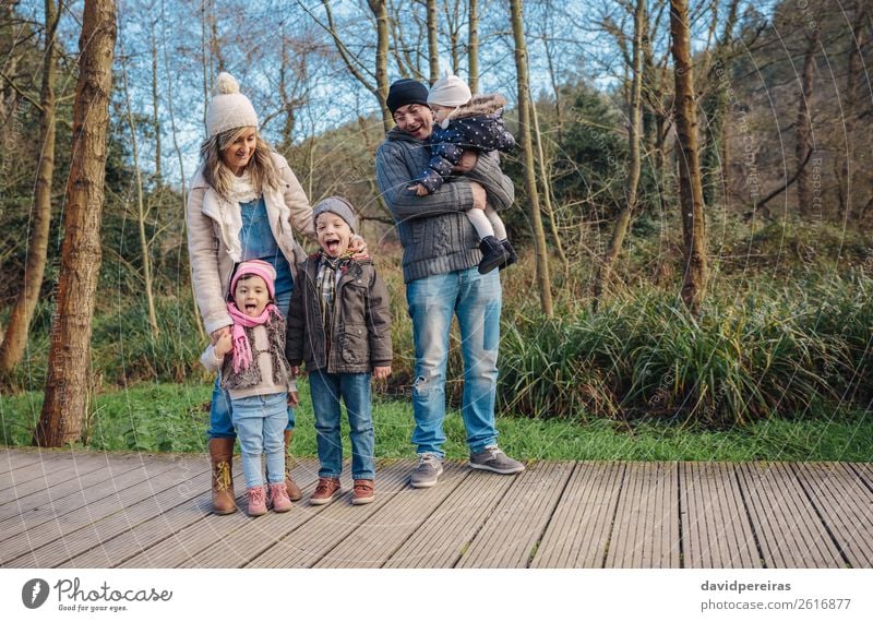 Portrait of happy family enjoying together leisure over a wooden pathway into the forest Lifestyle Joy Happy Leisure and hobbies Winter Child Baby Boy (child)