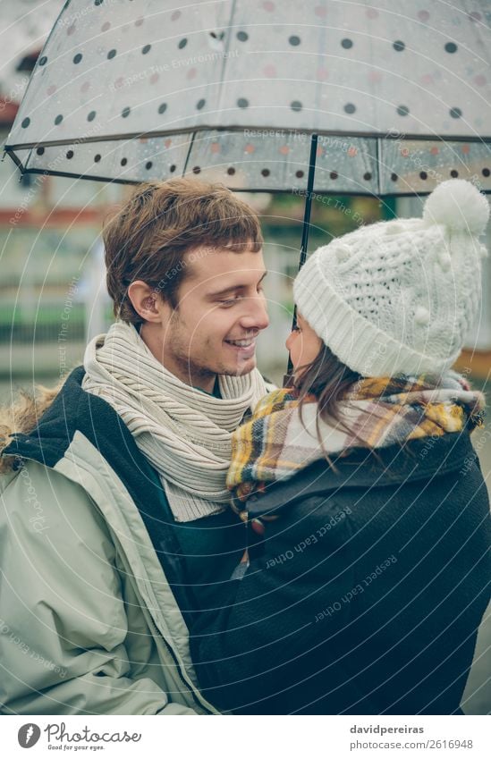 Young couple embracing under umbrella in a rainy day Lifestyle Happy Beautiful Winter Human being Woman Adults Man Family & Relations Couple Autumn Rain Street