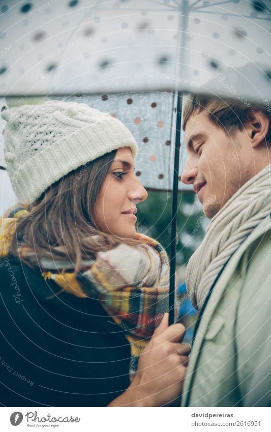 Young couple looking at each other under umbrella outdoors Lifestyle Happy Winter Human being Woman Adults Man Family & Relations Couple Autumn Rain Street