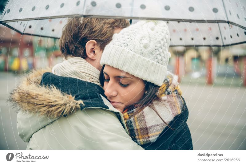 Young couple embracing outdoors under umbrella in a rainy day Lifestyle Beautiful Winter Human being Woman Adults Man Family & Relations Couple Autumn Rain