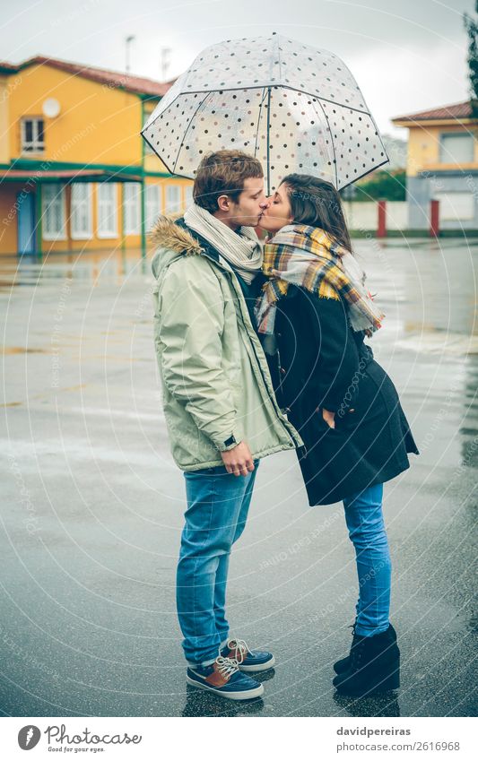 Young couple kissing outdoors under umbrella in a rainy day Lifestyle Beautiful Winter Human being Woman Adults Man Family & Relations Couple Autumn Rain Street