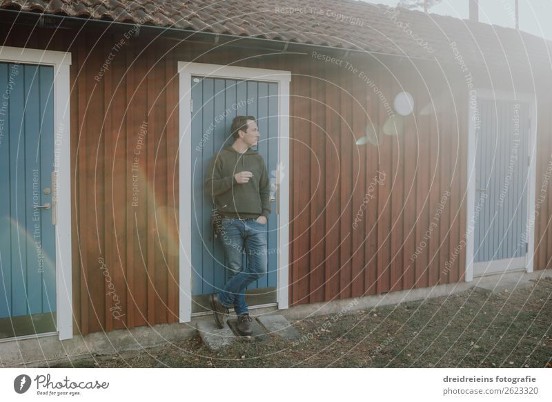 Man smokes cigarette in the sunlight in front of a house in Sweden Lifestyle Smoking Masculine Environment Sunlight Spring Summer Autumn Beautiful weather Hut