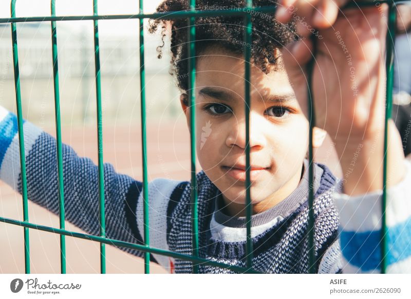 Little boy leaning at the metal fence of the playground Child School Boy (child) Hand Autumn Playground Metal Small Black Protection Safety (feeling of) Fence