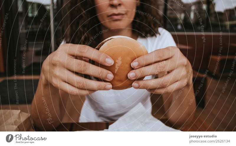 Young girl holding fast food burger Food Bread Lunch Fast food Lifestyle Style Beautiful Human being Woman Adults Hand Street Fashion Happiness Delicious