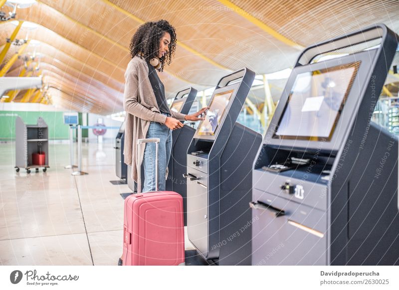 happy black woman using the check-in machine at the airport getting the boarding pass. Airport self Service Checkered Self-service Ticket Woman African American