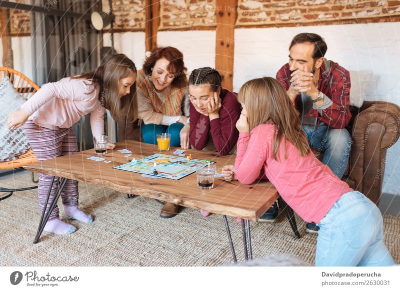 Happy family at home in the couch playing classic table games Family & Relations Table Playing Board Father Home Human being sisters Caucasian siblings Parents