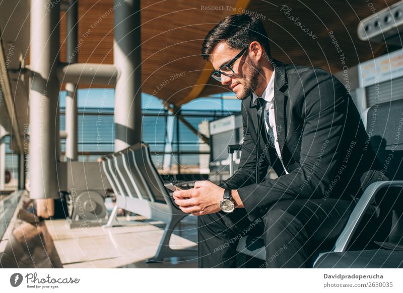 Young business man sitting on the phone with the suitcase at the airport waiting for the flight Airport Man Vacation & Travel Mobile Telephone Communication