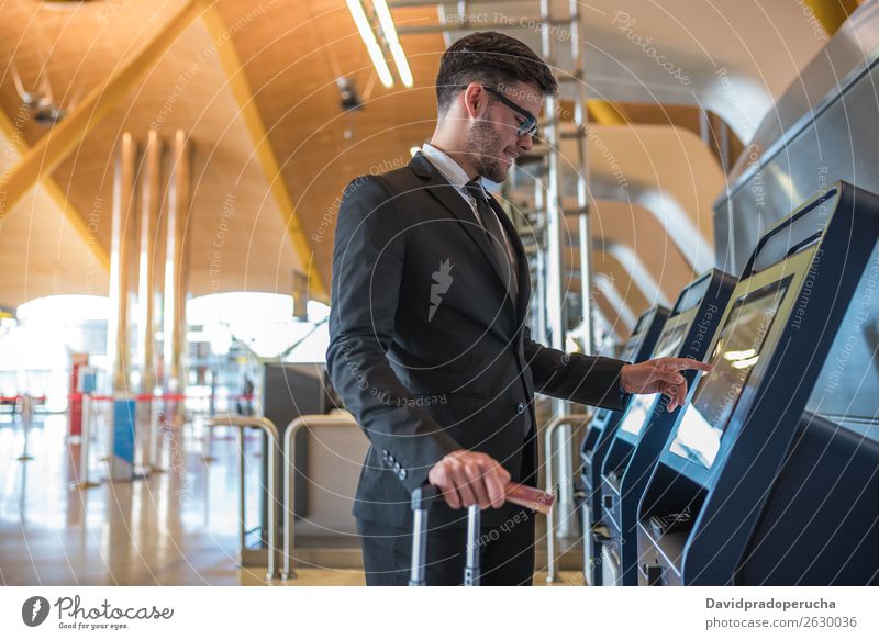 Young business man doing self check in a machine at the airport Airport Man Vacation & Travel Checkered Service Kiosk check-in Ticket Technology Wooden wall