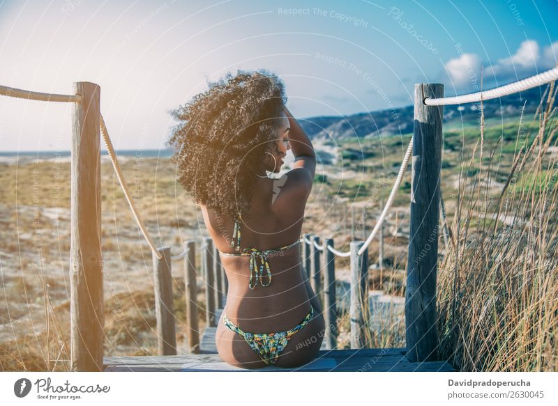 Beautiful young black woman sitting in a  wooden foot bridge at the beach Background picture Beach Bikini Black Bridge Coast Curly hair Destination Feet Hair