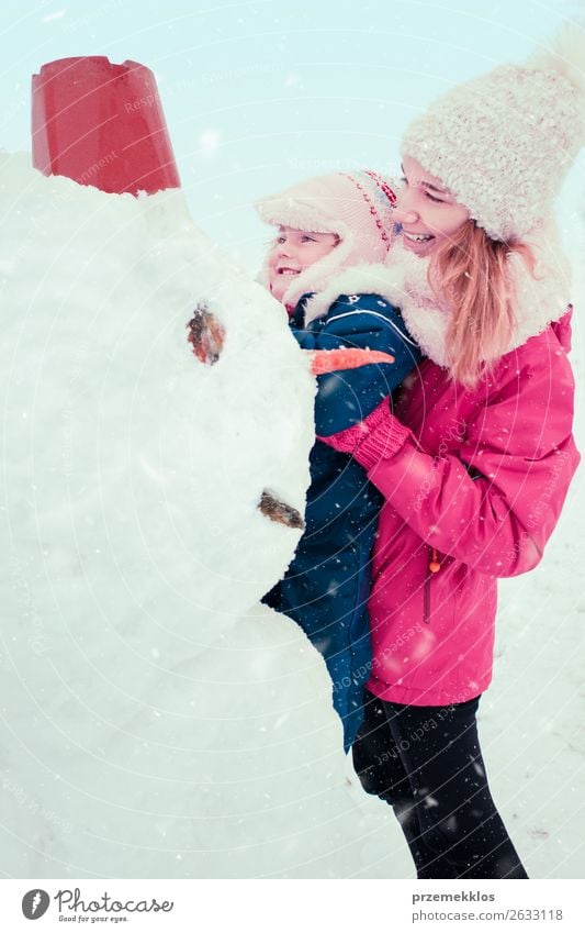 Girl and her little sister making a snowman Lifestyle Joy Happy Winter Snow Winter vacation Child Human being Young woman Youth (Young adults) Woman Adults