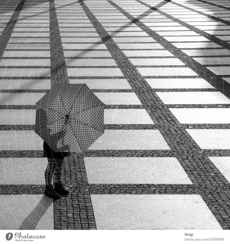 Woman standing in the backlight behind an open umbrella on a large square with plaid floor Human being Feminine Legs Feet 1 45 - 60 years Adults Chemnitz Town