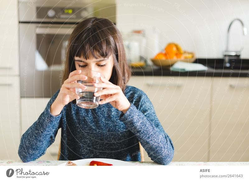 Cute thirsty girl drinking water in a glass at home Nutrition Eating Lunch Dinner Drinking Joy Happy Beautiful Table Kitchen Child Sit Appetite Thirsty kid