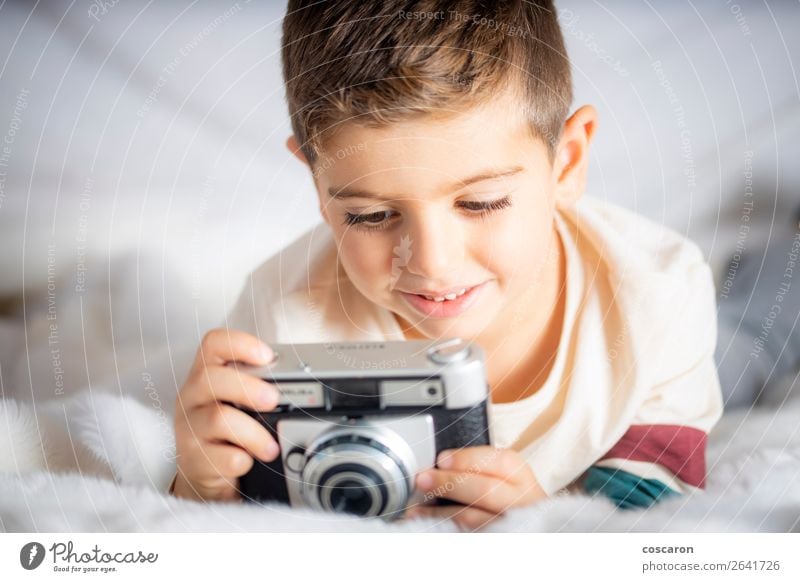 Beautiful boy with a photographing camera in the bed Lifestyle Joy Happy Face Vacation & Travel Child Camera Technology Human being Baby Toddler Boy (child)