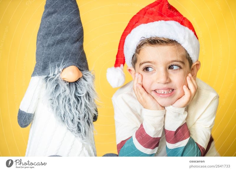 Child and a gnome with a yellow background on Christmas day Design Joy Happy Beautiful Face Winter Decoration Feasts & Celebrations Christmas & Advent