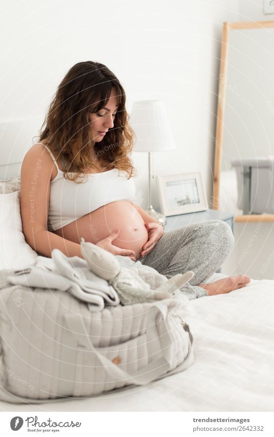 Pregnant woman touching her belly Lifestyle Happy Beautiful Leisure and hobbies Sofa Human being Baby Woman Adults Parents Mother Family & Relations Touch Love