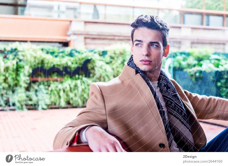 Young man wearing winter clothes in the street sitting Lifestyle Elegant Style Beautiful Hair and hairstyles Winter Human being Man Adults Youth (Young adults)