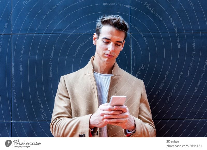 Young man wearing winter clothes in the street using the phone. Elegant Style Beautiful Hair and hairstyles Winter Telephone PDA Human being Man Adults