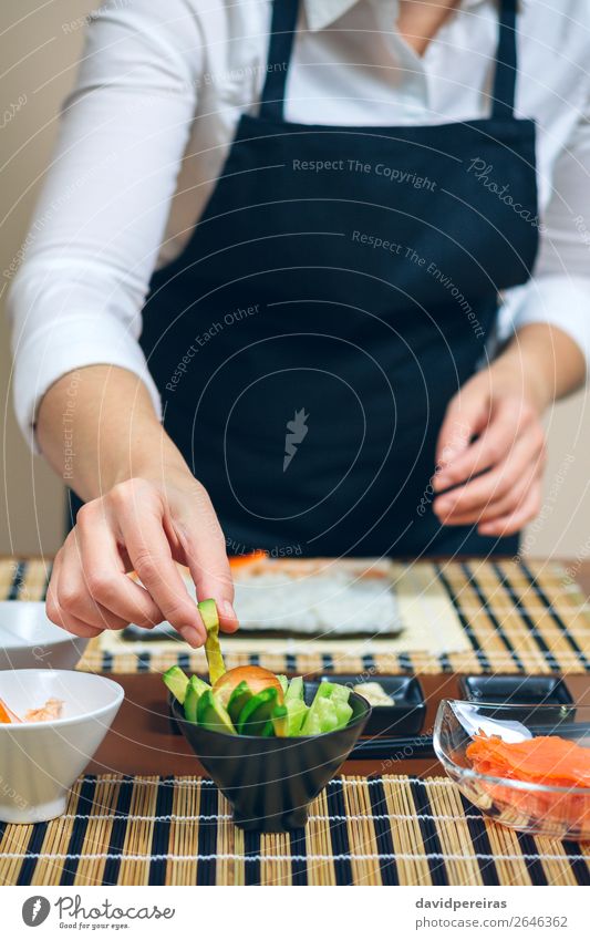 Chef picking up sliced avocado to make sushi Seafood Diet Sushi Restaurant Human being Woman Adults Hand Make Fresh chef Take preparing workshop Ingredients