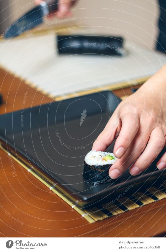 Woman chef placing japanese sushi rolls on a tray Sushi Plate Restaurant Adults Hand Make Fresh Black maki roll Putt Presentation food Tray rectangular Rice