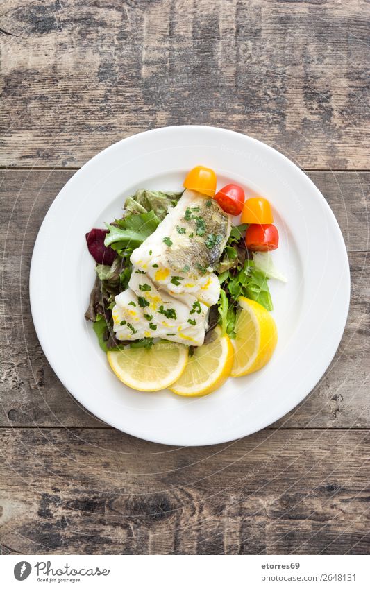 Fried cod fillet and salad in plate on wooden background Cod Fish Frying Salad Food Healthy Eating Food photograph Dish Plate follet Herbs and spices Nutrition