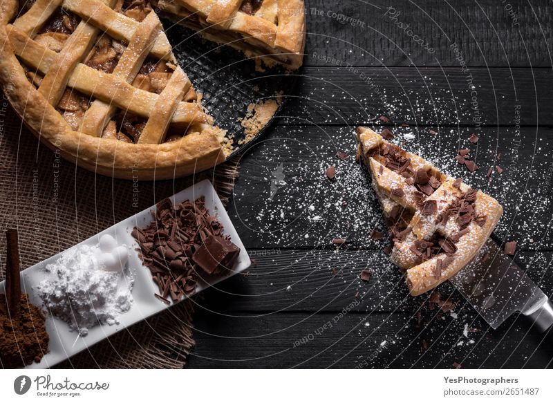 Traditional apple pie and slice with sweet condiments. Cake Dessert Candy Chocolate Plate Knives Table Kitchen Black Thanksgiving day above view American