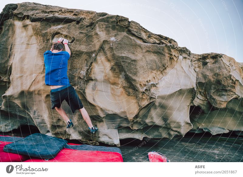 Young rock climber man bouldering Joy Happy Leisure and hobbies Adventure Ocean Mountain Hiking Sports Climbing Mountaineering Man Adults Nature Rock Coast