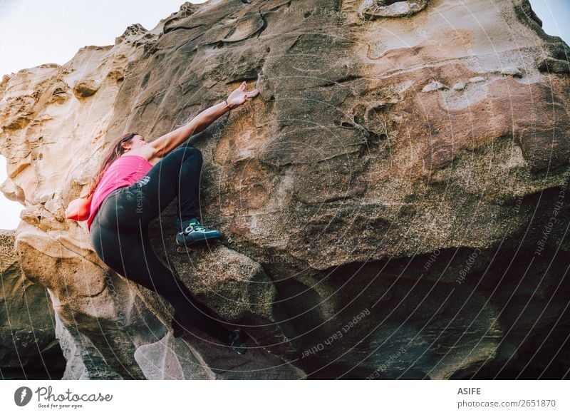 Young rock climber woman climbing the rock wall Joy Happy Beautiful Leisure and hobbies Adventure Ocean Mountain Hiking Sports Climbing Mountaineering Woman