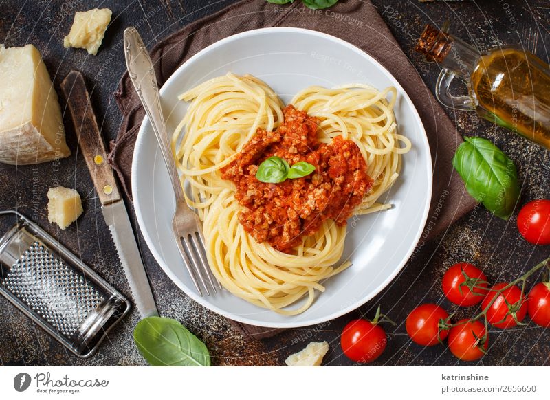 Spaghetti pasta with bolognese sauce Meat Cheese Herbs and spices Lunch Dinner Plate Fork Wood Bright Above Tradition Basil Beef Bolognese Cooking Dish food