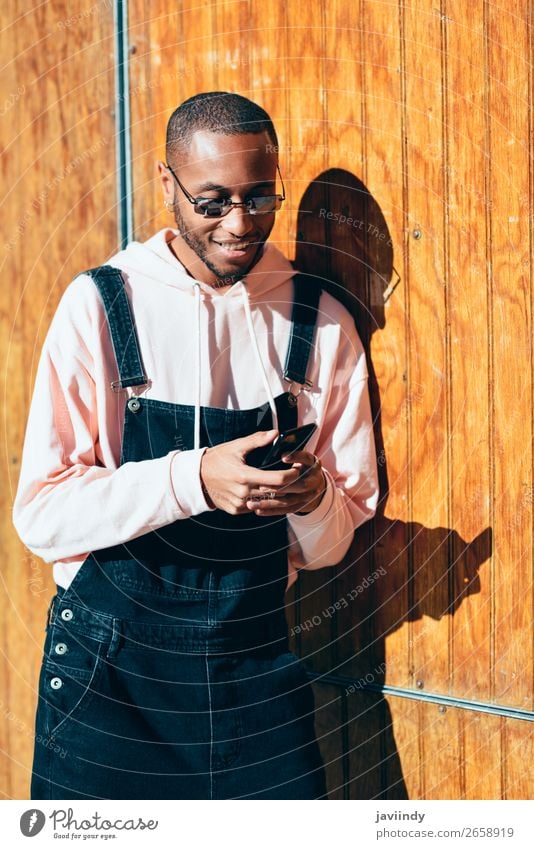 Young black man using smart phone outdoors Lifestyle Happy Beautiful Telephone PDA Technology Human being Masculine Young man Youth (Young adults) Man Adults 1