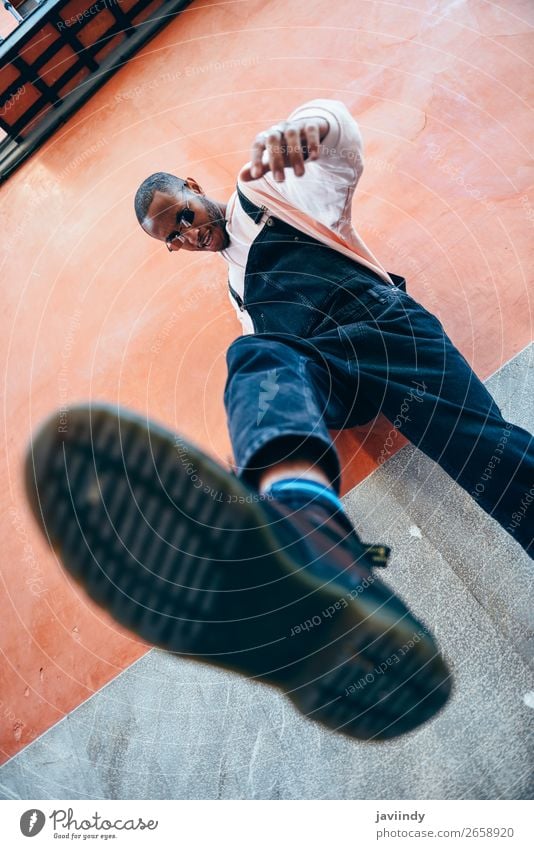 Young black man man kicking towards the ground. Lifestyle Beautiful Human being Masculine Young man Youth (Young adults) Man Adults 1 18 - 30 years Street Shirt