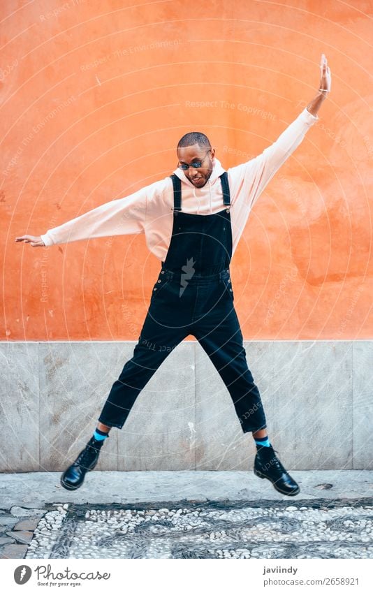 Young black man wearing casual clothes jumping in urban background. Lifestyle Joy Happy Beautiful Human being Masculine Young man Youth (Young adults) Man