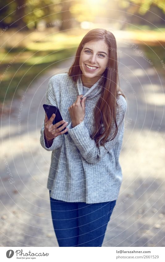 Woman using smartphone in park Lifestyle Happy Beautiful Reading Summer Telephone PDA Technology Internet Adults 1 Human being 18 - 30 years