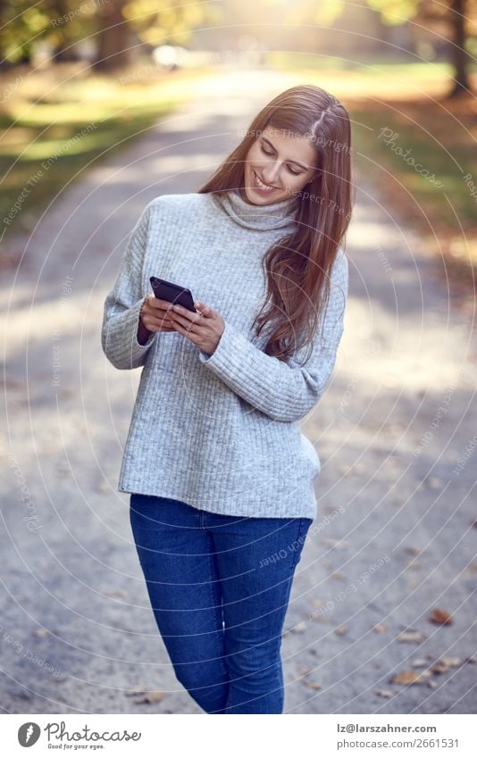 Woman using smartphone in park Lifestyle Happy Beautiful Reading Summer Telephone PDA Technology Internet Adults 1 Human being 18 - 30 years