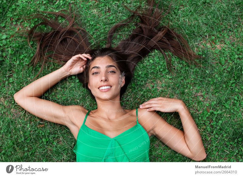 young cheerful woman lying down on the grass Lifestyle Happy Beautiful Leisure and hobbies Summer Human being Woman Adults Nature Grass Park Meadow Smiling