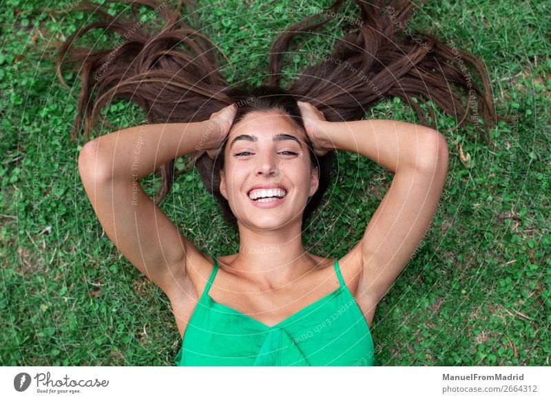 young cheerful woman lying down on the grass Lifestyle Happy Beautiful Leisure and hobbies Summer Human being Woman Adults Nature Grass Park Meadow Smiling