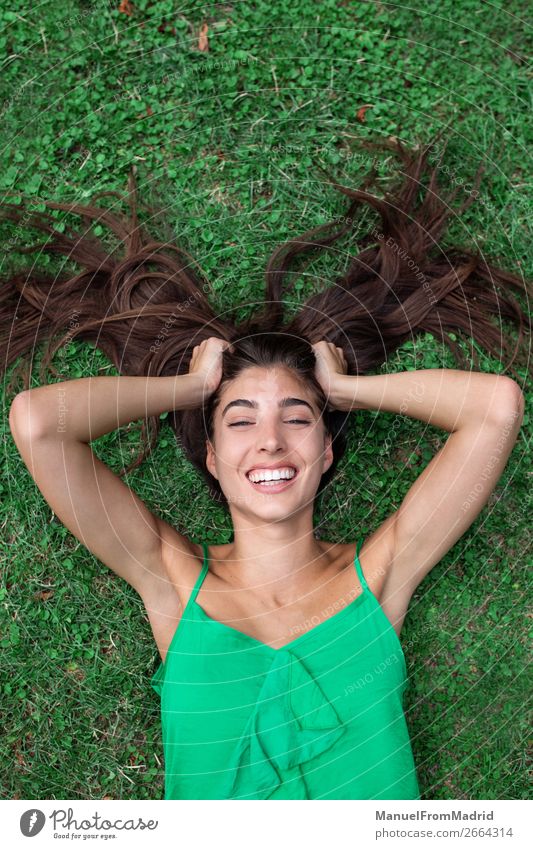 young cheerful woman lying down on the grass Lifestyle Happy Beautiful Leisure and hobbies Summer Human being Woman Adults Nature Grass Park Meadow Smiling