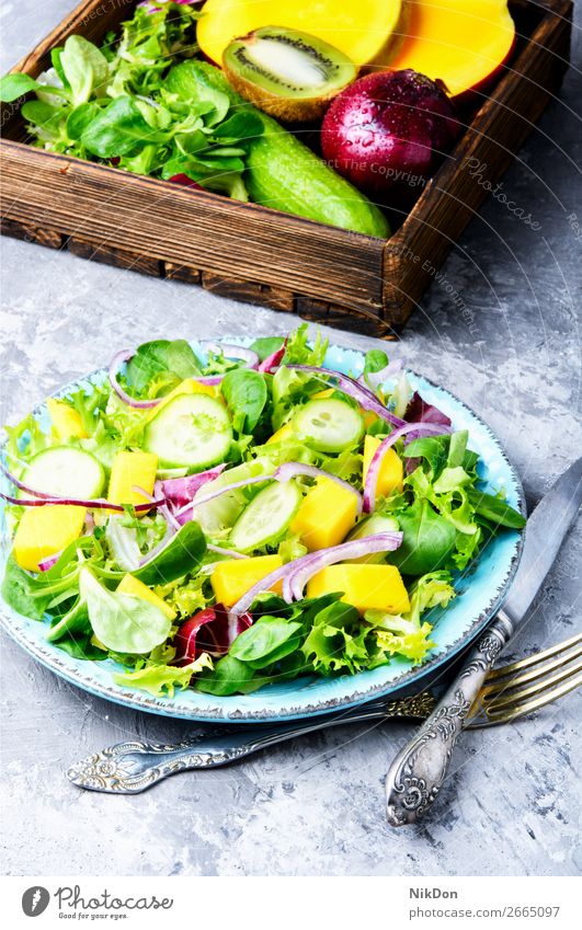 Lettuce salad with mango slices spring green lettuce vitamin leaf herb fresh food vegetable healthy diet vegetarian plate arugula natural cucumber fruit onion