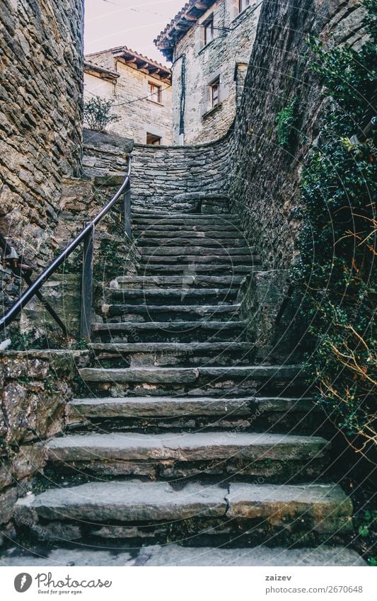 Stone ascendant stairs in a medieval village between stone walls with some houses in the background. Tourism House (Residential Structure) Plant Village Town