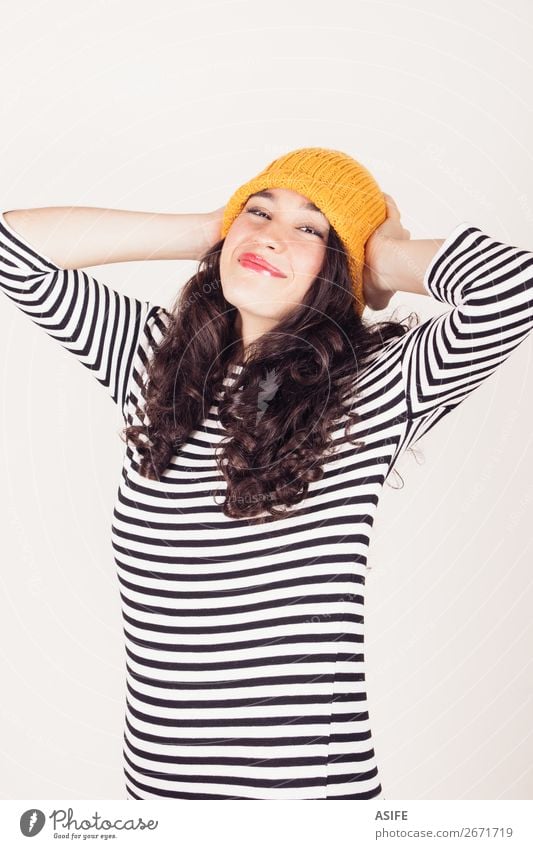 Happy autumn or winter girl with wool cap Beautiful Winter Woman Adults Autumn Dress Brunette Smiling Happiness Funny Yellow Black White Wool isolated ocher