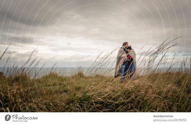 Young couple embracing outdoors under blanket in a cold day Lifestyle Happy Beautiful Ocean Winter Mountain Woman Adults Man Couple Nature Sky Clouds Autumn