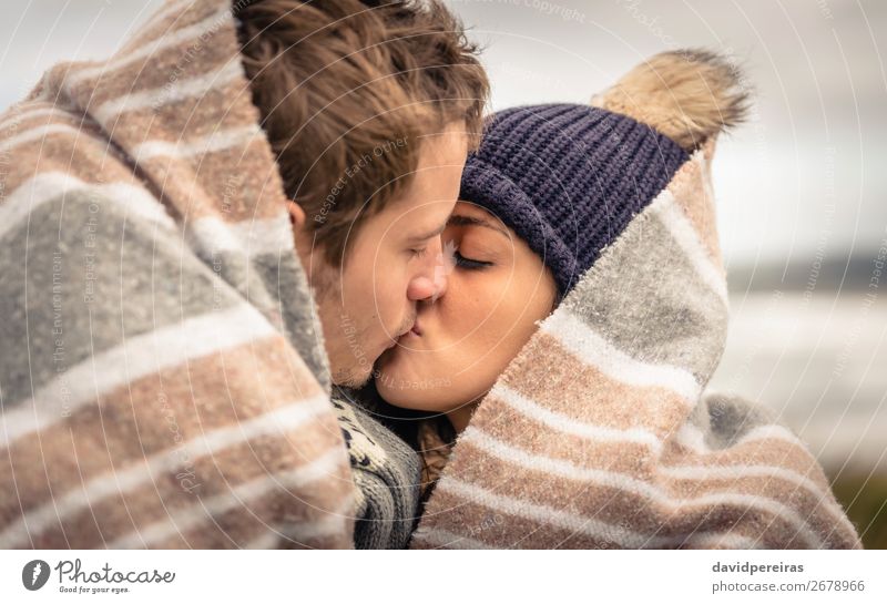 Young couple kissing outdoors under blanket in a cold day Lifestyle Happy Beautiful Ocean Winter Mountain Woman Adults Man Couple Nature Sky Clouds Autumn Wind