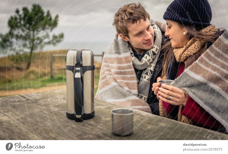 Young couple under blanket having hot drink in a cold day Beverage Coffee Tea Lifestyle Happy Winter Table Woman Adults Man Couple Hand Nature Sky Clouds Autumn