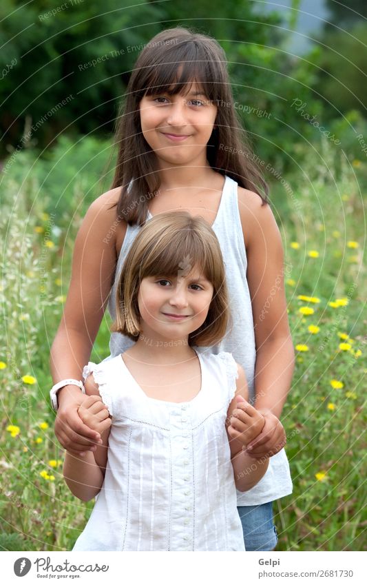 Two beautiful smiling sisters Lifestyle Joy Happy Beautiful Face Child Human being Woman Adults Sister Couple Infancy Mouth Flower Grass Brunette Blonde Smiling