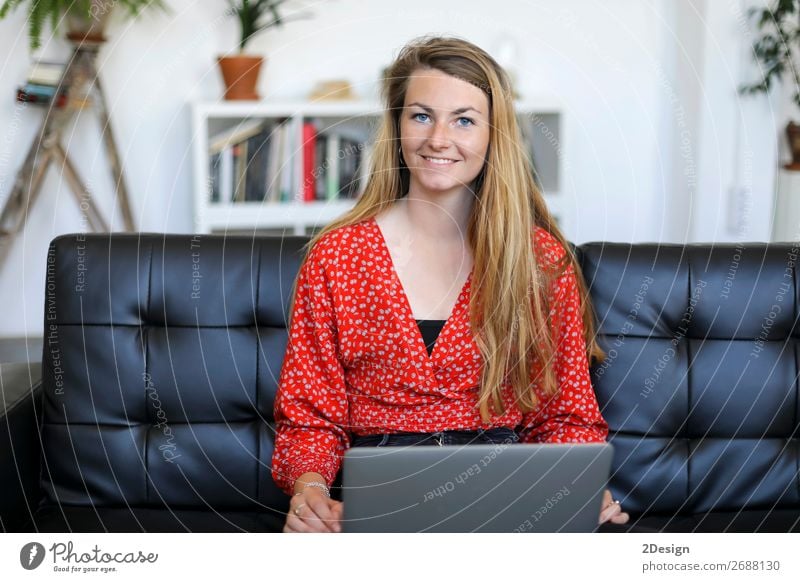 Smiling woman sitting on a sofa at home using a laptop Shopping Happy Beautiful House (Residential Structure) Sofa School Study Academic studies