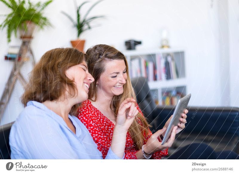 Women at home sitting on sofa while using a tablet PC Lifestyle Joy Happy Beautiful Relaxation Flat (apartment) House (Residential Structure) Sofa To talk