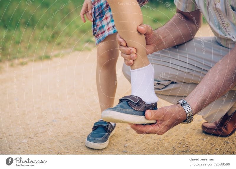 Grandfather putting shoe to his grandson outdoors Lifestyle Leisure and hobbies Summer Garden Child Human being Boy (child) Man Adults Parents